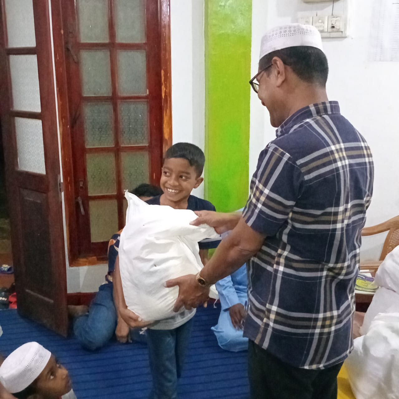 A young recipient receiving a Ramadan food pack